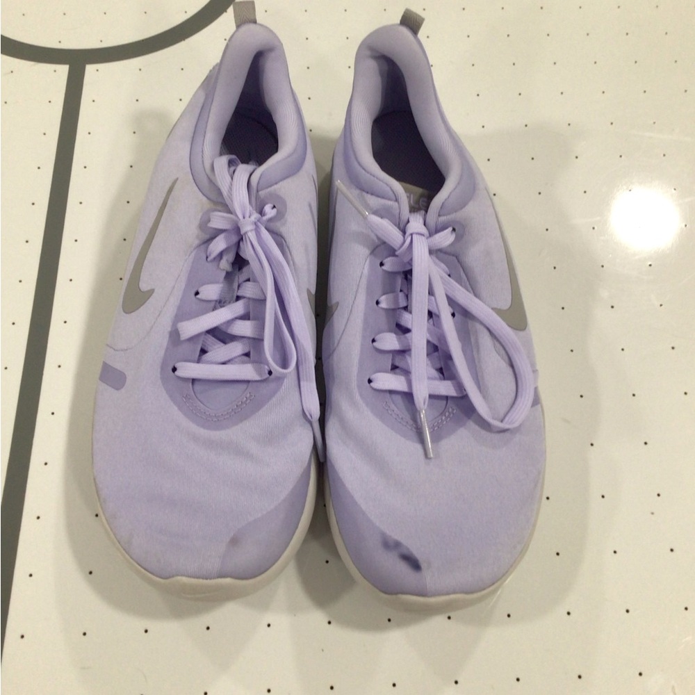 Light purple Nike sneakers with a stain on the right shoe